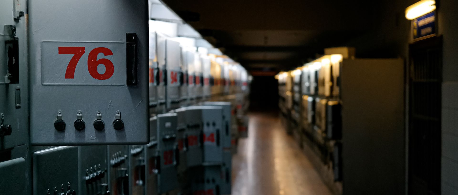 Rows of numbered switchgear cabinets receding down a facility electrical room